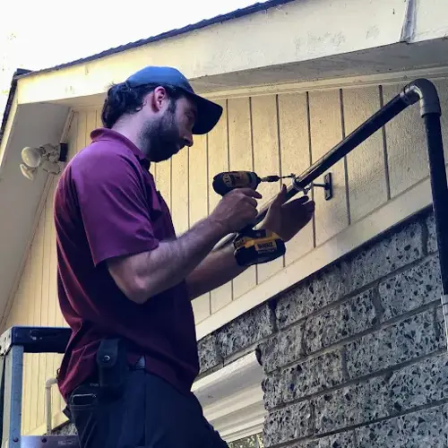 Total Comfort plumber in Fredericksburg, VA, repairing exterior pipe on a residential home.